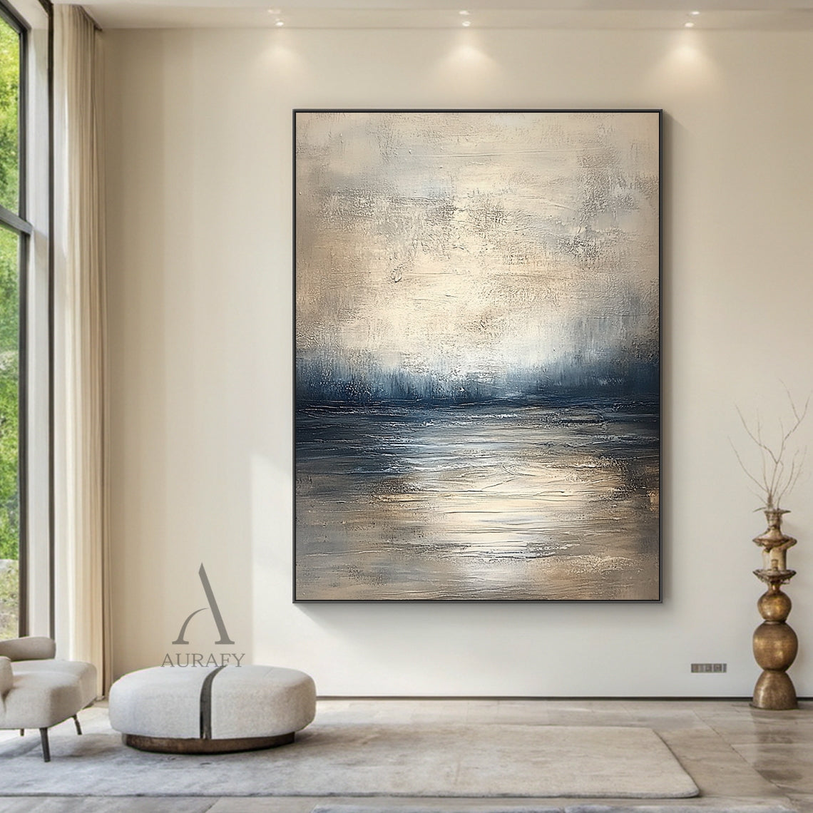 Abstract beige blue wall art (AURA405) real-life decor display shot, retains knife stroke textured surface, horizontal layered composition with soft gradient between light beige, gray beige, deep blue and gray blue tones that evokes calm water surface, distant shoreline and misty hazy sky in sequence. This image shows the artwork matched with narrow natural wood frame hung above a beige linen soft package headboard as bedroom background decor, the handcrafted thick paint texture delivers serene tranquil nat