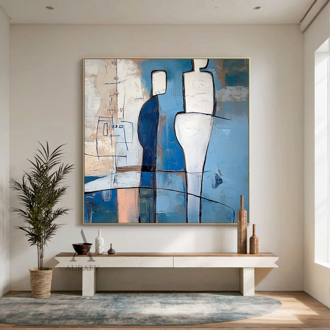 Blue abstract wall art (AURA648) displayed hung on a soft grey entryway accent wall opposite the front door, above a slim rattan-trimmed solid wood shoe bench with hidden storage, featuring its signature tactile layered brushstrokes and bold black outlined geometric humanoid forms. The artwork includes two central contrasting figures: a deep navy blocky figure with white head, a taller fluid curved white figure, plus a delicate thin blue line sketch humanoid on the left, with a painterly background in sky b