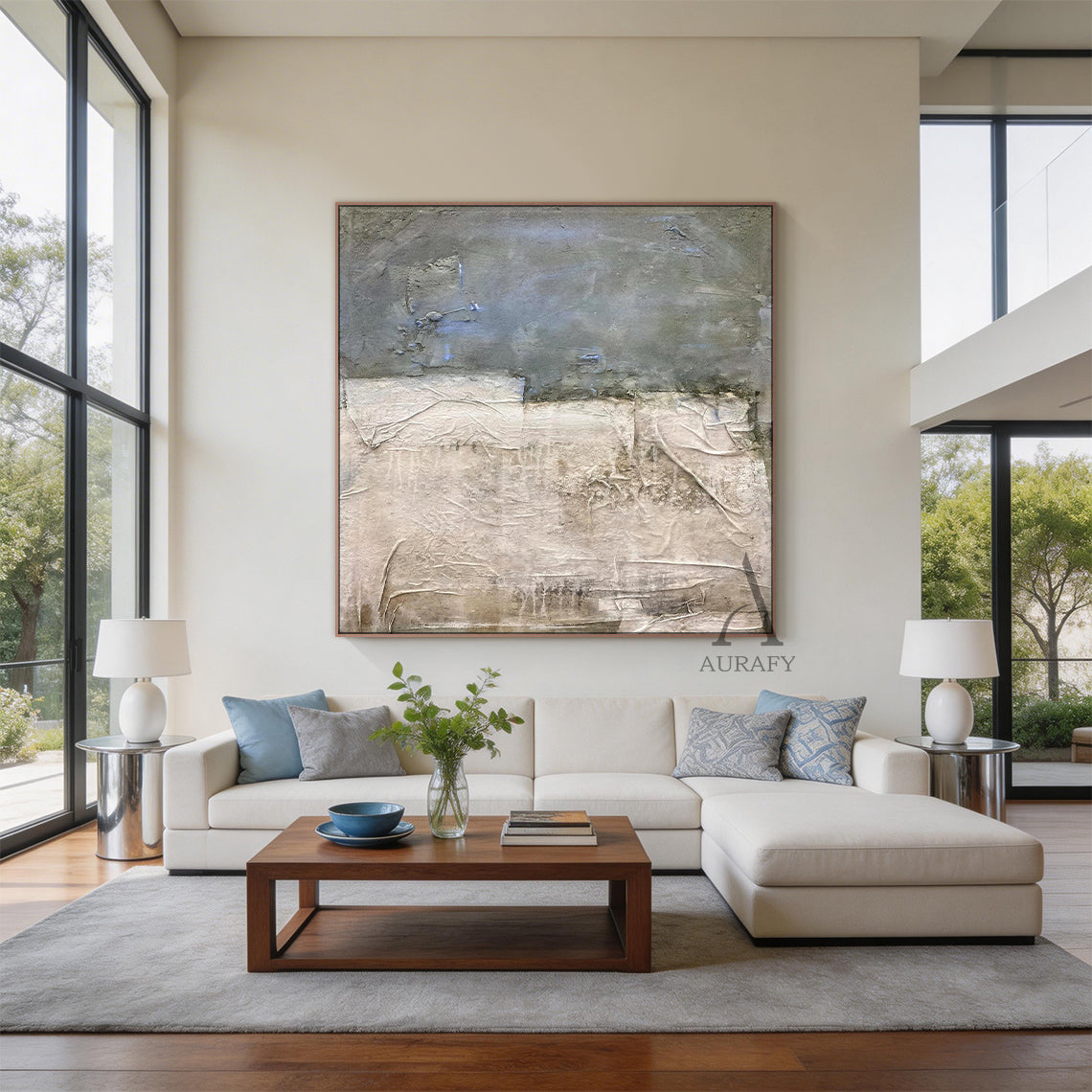 Blue General Abstract Wall Art AURA244: Textured modern decor piece with dark gray upper section (subtle blue accents) and light beige lower section (rough layered brushstrokes) in a warm brown frame. Displayed in a modern living room (neutral beige walls, concrete floor, gray armchair, wooden planter)—ideal as a minimalist interior statement piece or office accent wall art for contemporary spaces. This abstract wall art adds depth and artistic flair to living rooms, offices, or minimalist interiors, servin