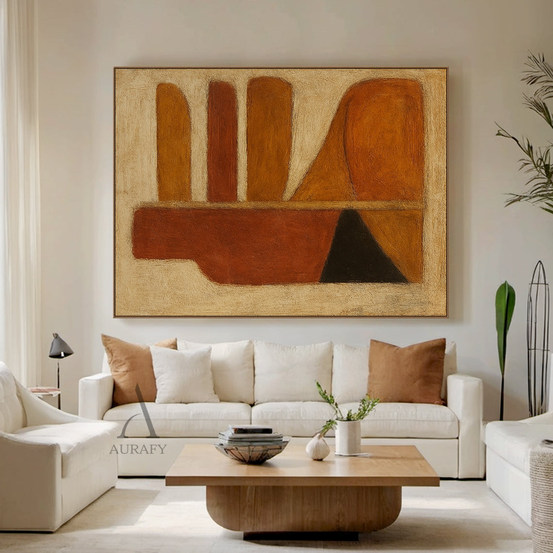 Handcrafted abstract brown wall art with tactile brushstroke texture and organic geometric composition, styled in a real home living space. The piece retains its signature design: left side with a vertical deep rust red-brown bottle-shaped silhouette, matched with black and orange-brown triangular blocks at the base, right side with rounded horizontal strips in warm amber, rust and brown tones plus curved orange-brown blocks, all set against a muted off-white textured background. This warm minimalist wall d