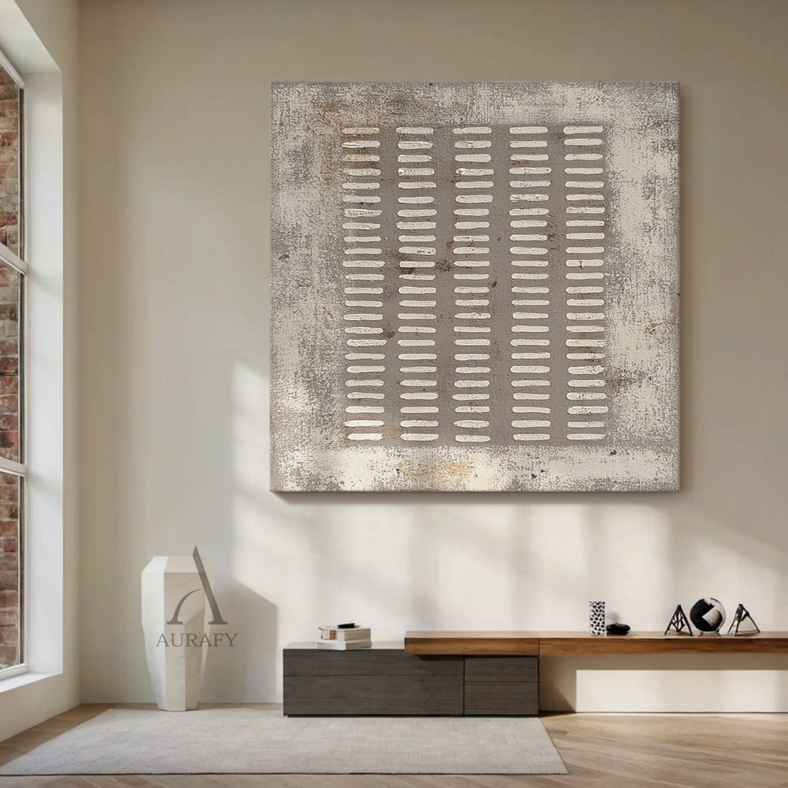 Square gray abstract plaster textured wall art (AURA628) real home scene display, the artwork with 5 vertical columns of irregular handcrafted white short rectangular lines on muted distressed gray base is presented in actual space matching, this rough weathered canvas-like textured wabi-sabi modern organic minimalist piece fits perfectly with the surrounding furnishings, providing intuitive reference for Japandi, neutral minimalist home decor selection.