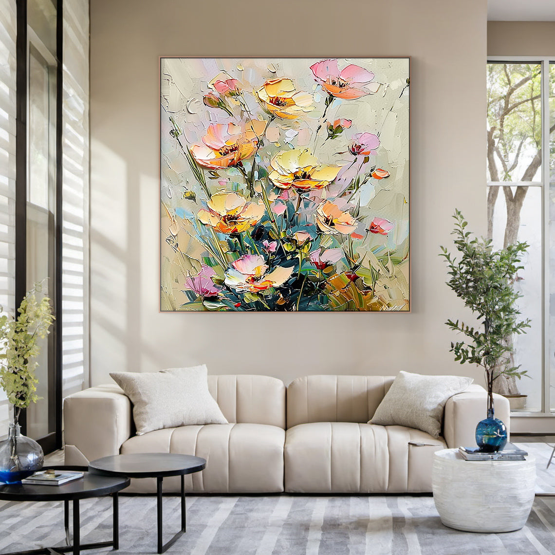 Impasto palette knife oil painting of wild clustered florals, presented in a sunlit warm minimalist dining nook styling scene. The artwork features fully bloomed, half-opened and budding flowers in soft buttery yellow, blush pink, light peach shades, paired with muted sage green stems and foliage against a neutral creamy beige textured background. Thick raised paint strokes create a distinct tactile hand-painted texture, following the impressionist wabi-sabi decorative style, which complements rattan furnis