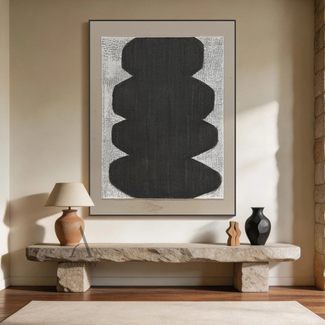 Minimalist abstract Japandi wabi-sabi wall artwork AURA727, square raw woven canvas with clear grid texture, features stacked soft curved matte black organic form with no sharp edges, monochrome black, white and neutral gray color palette, canvas weave texture visible through both painted and unpainted areas, set against a light taupe matte border, tactile neutral decor piece for calm curated modern home spaces.