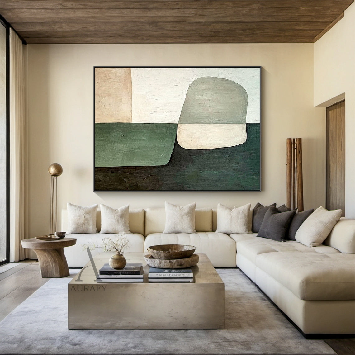 AURA405 modern organic abstract wall art, oil-acrylic blend with tactile brush stroke texture, features soft-edged muted dark green, sage green, warm beige and off-white color blocks with a two-tone irregular oval shape at lower center, displayed hung above a light oak sideboard in a sunlit Japandi entryway, balanced earthy tone abstract artwork suitable for minimalist, quiet luxury and natural style home interior decor
