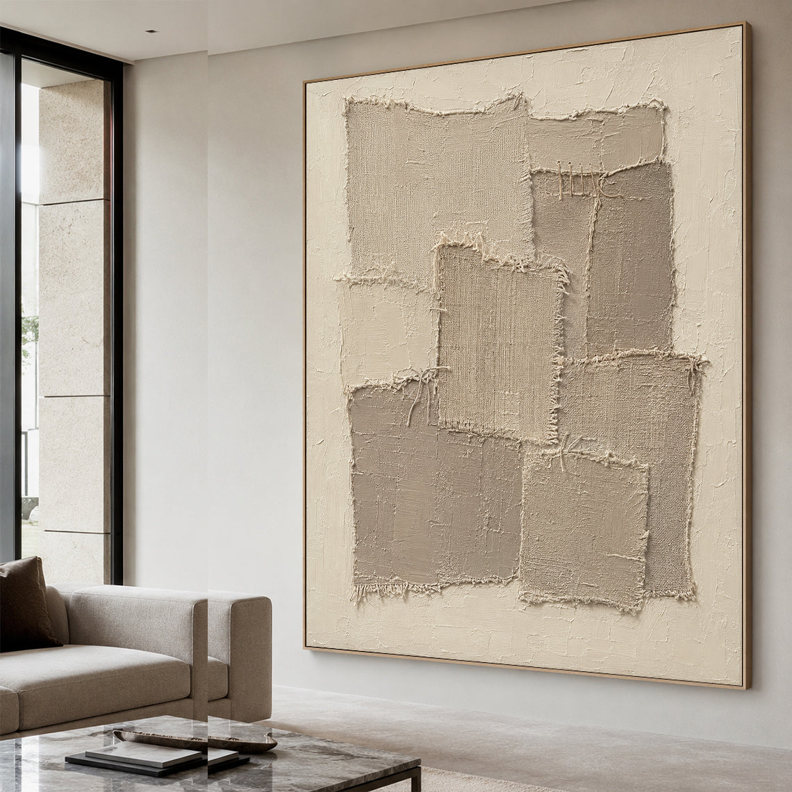 Handcrafted wabi sabi beige 3D textured canvas wall art propped on a natural rattan side cabinet in a sun-dappled Japandi style living nook, with overlapping frayed raw woven fabric patches and hand-stitched cord accents set on a thick rough matte cream impasto base. The full palette covers soft muted warm beige, oat and light taupe neutral earth tones, it is a minimalist tactile neutral wall decor that blends perfectly into light wood interiors, calm reading nooks, bohemian bedrooms and cozy entryway space