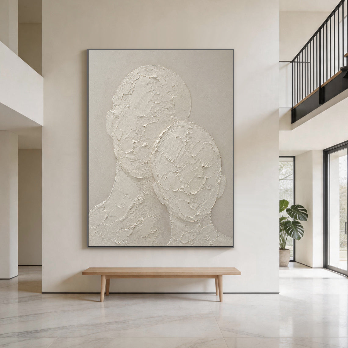 Wabi-sabi beige 3D textured plaster canvas wall art hung on the warm beige accent wall of a calm Japandi living room, handcrafted with thick impasto knife strokes, displays two faceless abstract head and neck silhouettes in an intimate leaning snuggling pose. It has raised, cracked, rough tactile texture against a smooth muted warm beige background, with a monochromatic neutral off-white soft taupe palette, this minimalist Japandi figurative artwork perfectly fits cozy curated home interior decor.