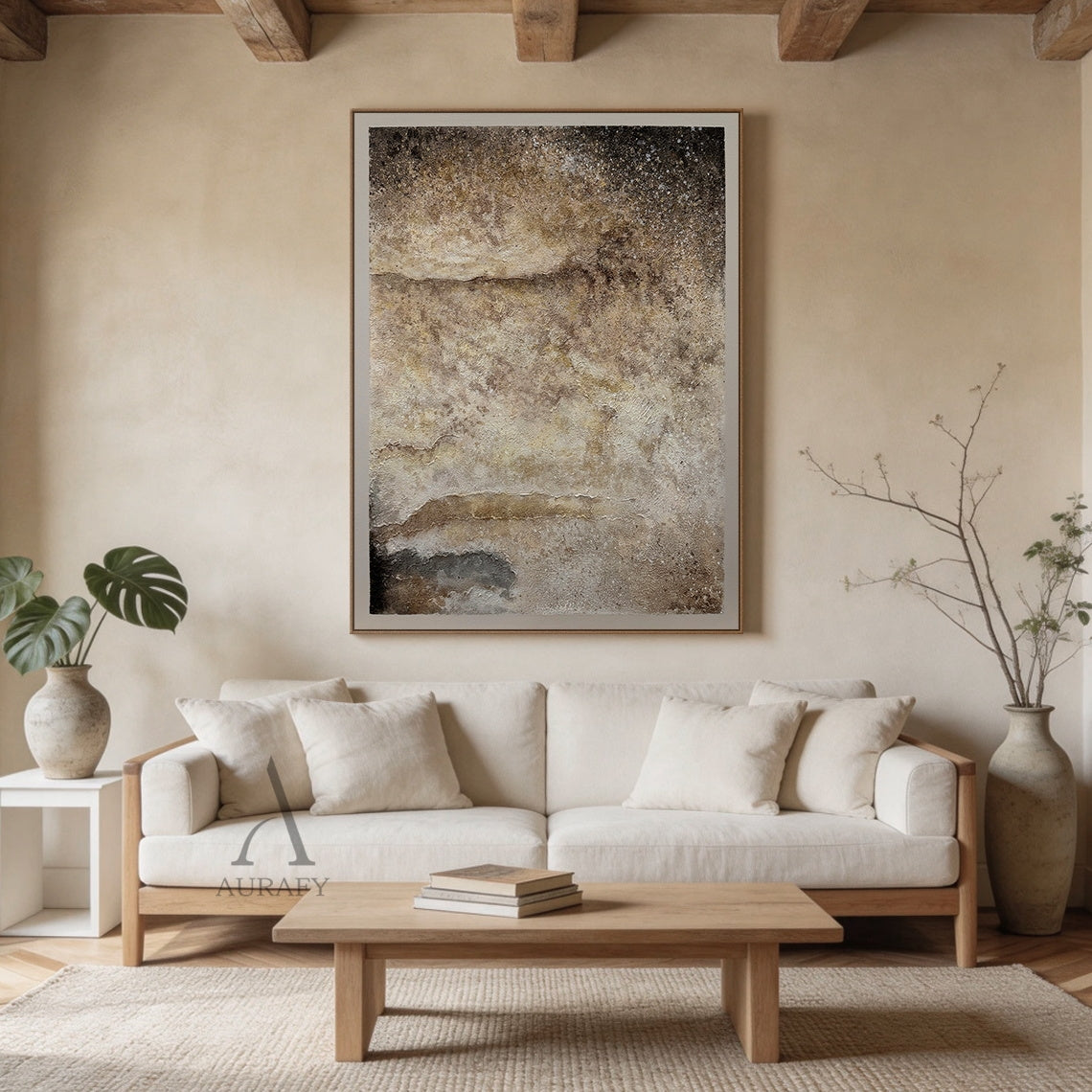 Wabi-Sabi general abstract textured wall art handcrafted with thick impasto technique, features a rough uneven surface mimicking weathered rammed earth, sediment rock and aged plaster. It adopts a muted neutral earthy palette of beige and varied brown tones, with irregular horizontal strata lines echoing natural coastal landforms, tiny mineral-like white flecks scattered across the texture. Its color gradient softens from deep dark brown at the upper edge to light cream beige at the lower section, with a da