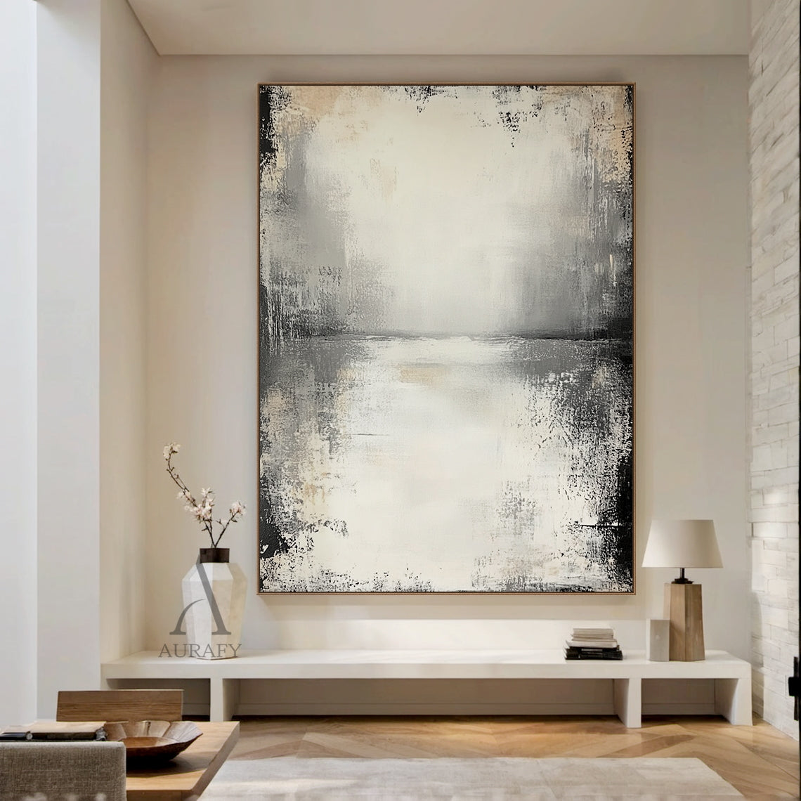 Wabi-sabi beige abstract textured canvas wall art AURA719, styled and displayed hung above a narrow solid light oak dining sideboard against a creamy white limewashed wall in a warm airy Japandi dining nook filled with soft golden afternoon sunlight, features a muted neutral color palette of off-white, pale beige, light to deep charcoal gray with faint warm brown accents, hand-finished distressed brushed & wiped texture with rough worn edges, subtle horizontal abstract sky-water horizon line across the uppe