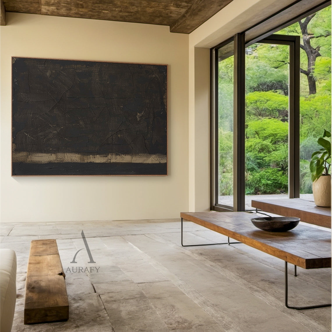 Wabi Sabi Black Abstract Cracked Textured Japandi Canvas Wall Art AURA796 (Scene Display Edition): Minimalist luxe neutral decor artwork presented in real home styling context, retaining its signature deep inky black heavy impasto main field, natural craquelure cracked texture across the full dark surface, subtle warm ochre and gilded undertones peeking through worn hand-applied brush strokes and paint gaps, a muted sand-toned horizontal anchor band at the base, raw woven canvas texture visible through pain