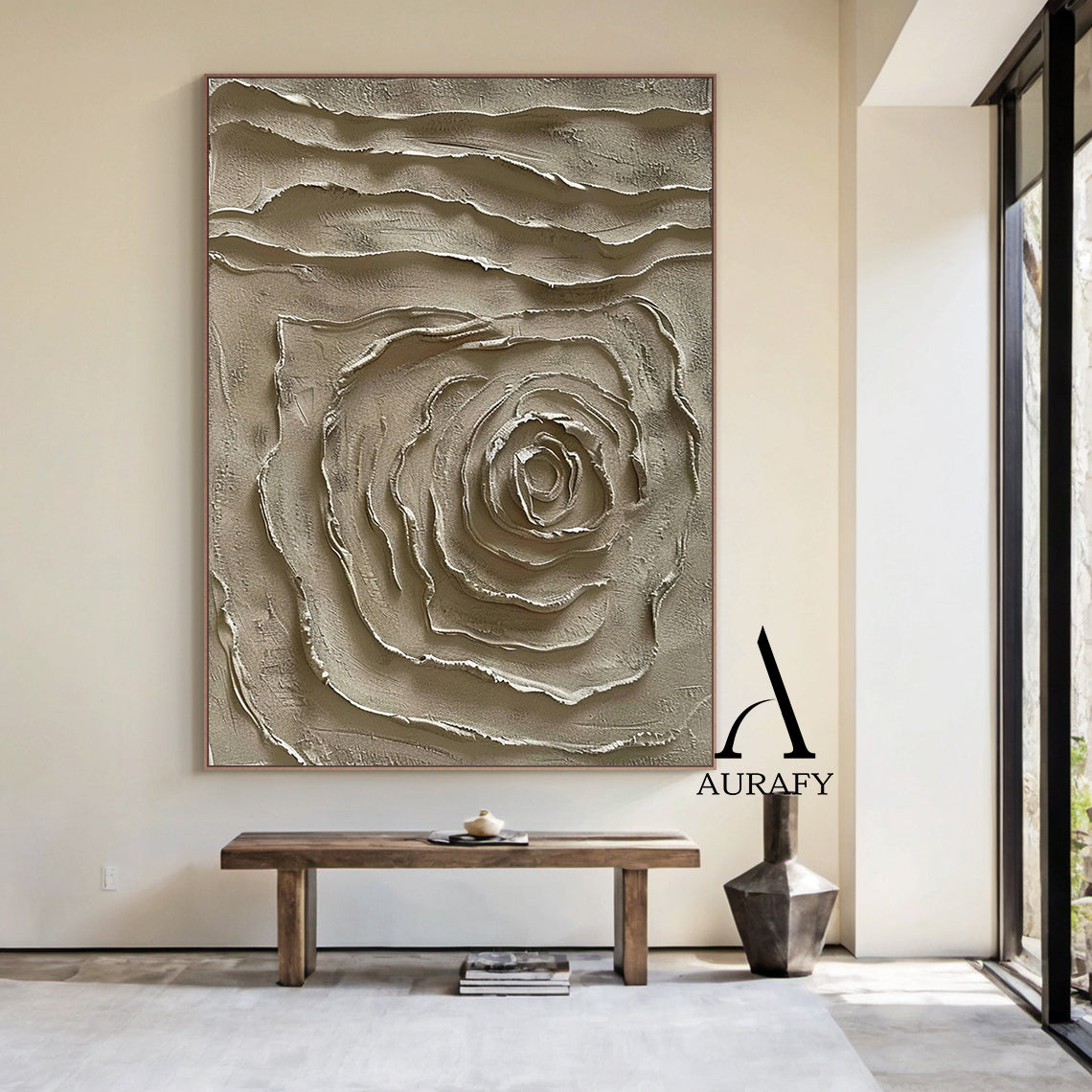 Real home living room wall hanging display of handcrafted 3D textured plaster painting in muted warm brown earth tone, features raised impasto spiral abstract rose motif at lower half and horizontal wavy layered textured bands on upper section, matte tactile high-relief wabi-sabi japandi minimalist wall art, AURA538 by Aurafy