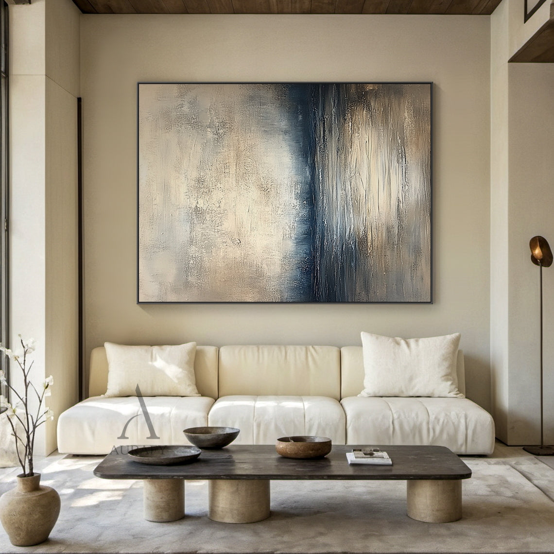 Abstract beige blue wall art (AURA405) real-life decor display shot, retains knife stroke textured surface, horizontal layered composition with soft gradient between light beige, gray beige, deep blue and gray blue tones that evokes calm water surface, distant shoreline and misty hazy sky in sequence. This image shows the artwork matched with natural wood frame hung above a beige linen sofa as living room background decor, the handcrafted thick paint texture delivers serene tranquil natural vibe, perfectly 