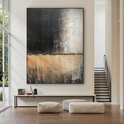 General abstract impasto canvas wall artwork AURA405, displayed as hanging decor in a minimalist Japandi living scene above a low-profile solid oak side cabinet against a plain off-white wall: it retains the iconic horizontally split textured composition, upper zone with thick textured deep black paint scattered with tiny white star-like specks gradually fading to muted light beige, lower zone with layered earthy beige, warm tan and dark brown tones with vertical dragged brushstrokes presenting distinct ero