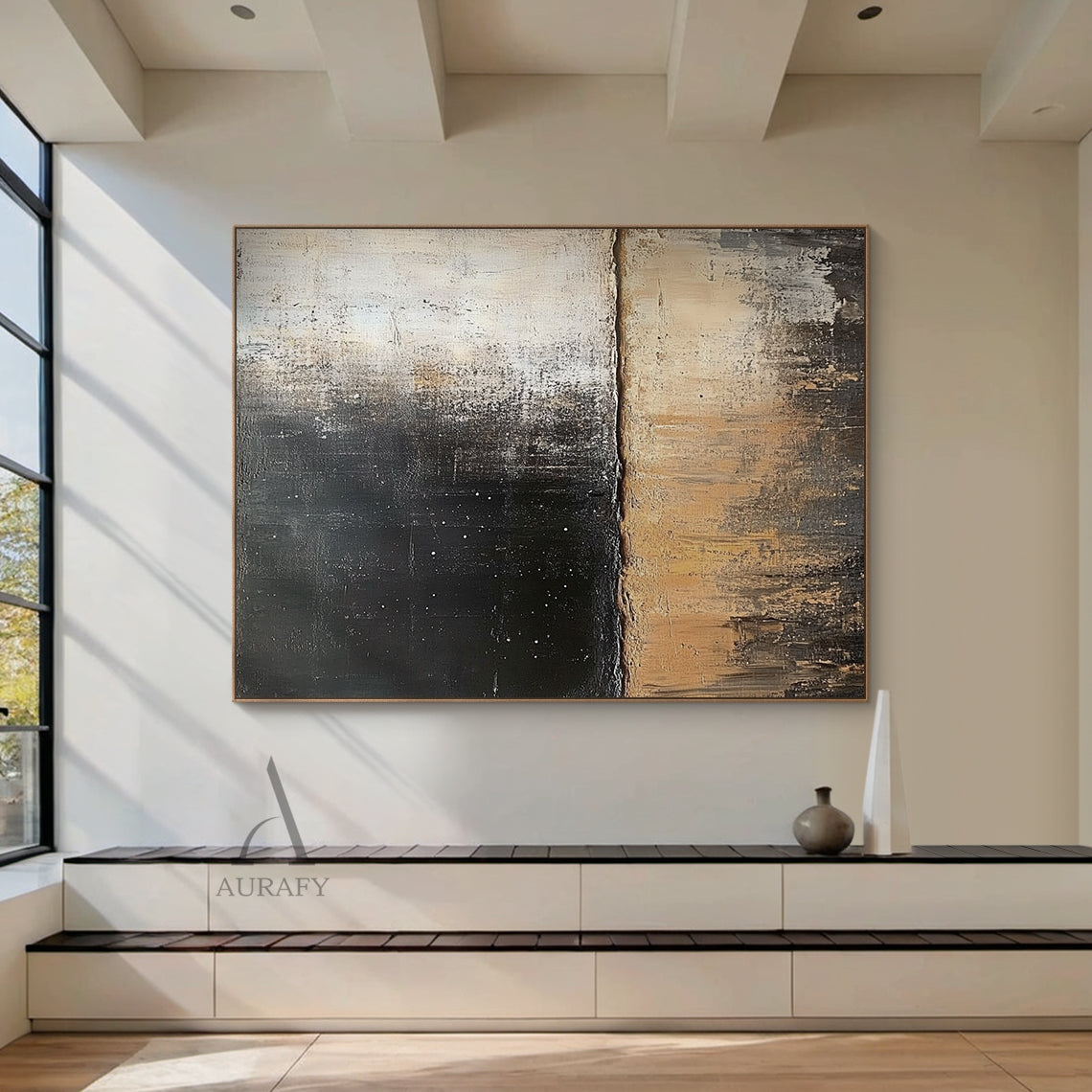General abstract impasto canvas wall artwork AURA405, displayed as hanging decor in a minimalist Japandi living scene above a low-profile solid oak side cabinet against a plain off-white wall: it retains the iconic horizontally split textured composition, upper zone with thick textured deep black paint scattered with tiny white star-like specks gradually fading to muted light beige, lower zone with layered earthy beige, warm tan and dark brown tones with vertical dragged brushstrokes presenting distinct ero