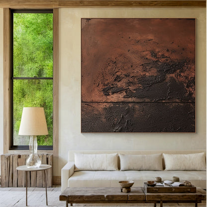 Abstract impasto painting with terracotta tones and bold black accents as the focal point in a modern minimalist living room. Thick tactile texture, horizontal composition, and earthy hues infuse warm rustic charm into the space—light gray linen sofa, wooden coffee table with glass top, geometric wool rug, sleek floor lamp, potted fiddle-leaf fig in a matte ceramic pot. Soft natural light filtering through sheer curtains over large windows, with distant greenery visible outside, ideal for Japandi or Scandin