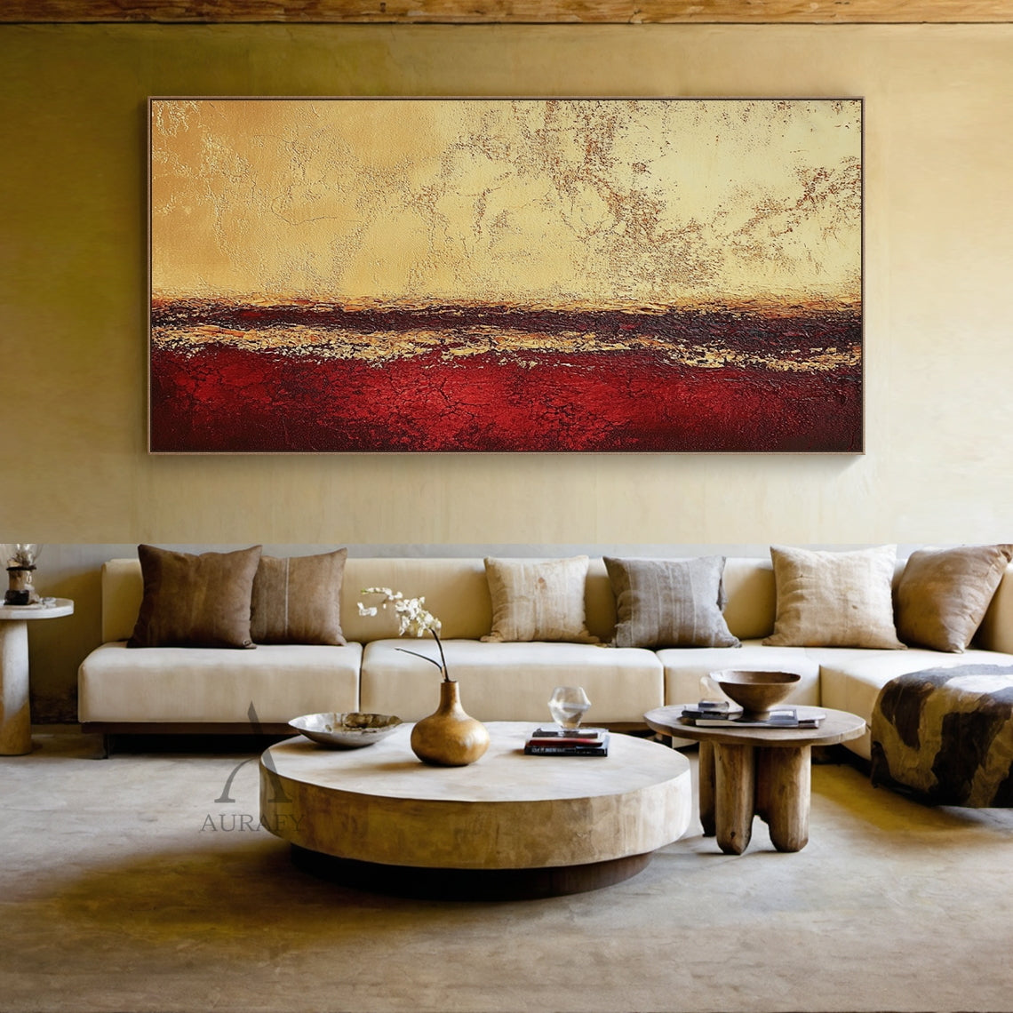 Abstract Red Yellow Textured Wall Art AURA405 (Real Living Room Sofa Background Wall Scene Display), geological stratum inspired horizontal layered abstract artwork. The top zone is light yellow-beige with cracked weathered sun-bleached texture, the middle dark band blends deep brown and maroon with uneven golden-yellow streaks, the bottom part is saturated deep red with prominent crackle textures. Wabi-sabi style tactile wall decor showing actual hanging effect above the sofa, suitable for Japandi, minimal