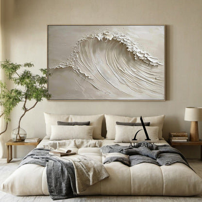 AURAFY beige monochrome high relief impasto canvas wall art hung in a neutral-toned home space, handcrafted with thick sculpted plaster/heavy acrylic texture to present a vivid rolling cresting sea wave. Multi-layered raised strokes form the soft flowing curve of the wave body, ragged uneven raised edges at the top simulate the foamy splashing of breaking surf, paired with a smooth matte warm beige background. The 3D textured surface produces natural varied light and shadow layers under indoor ambient light