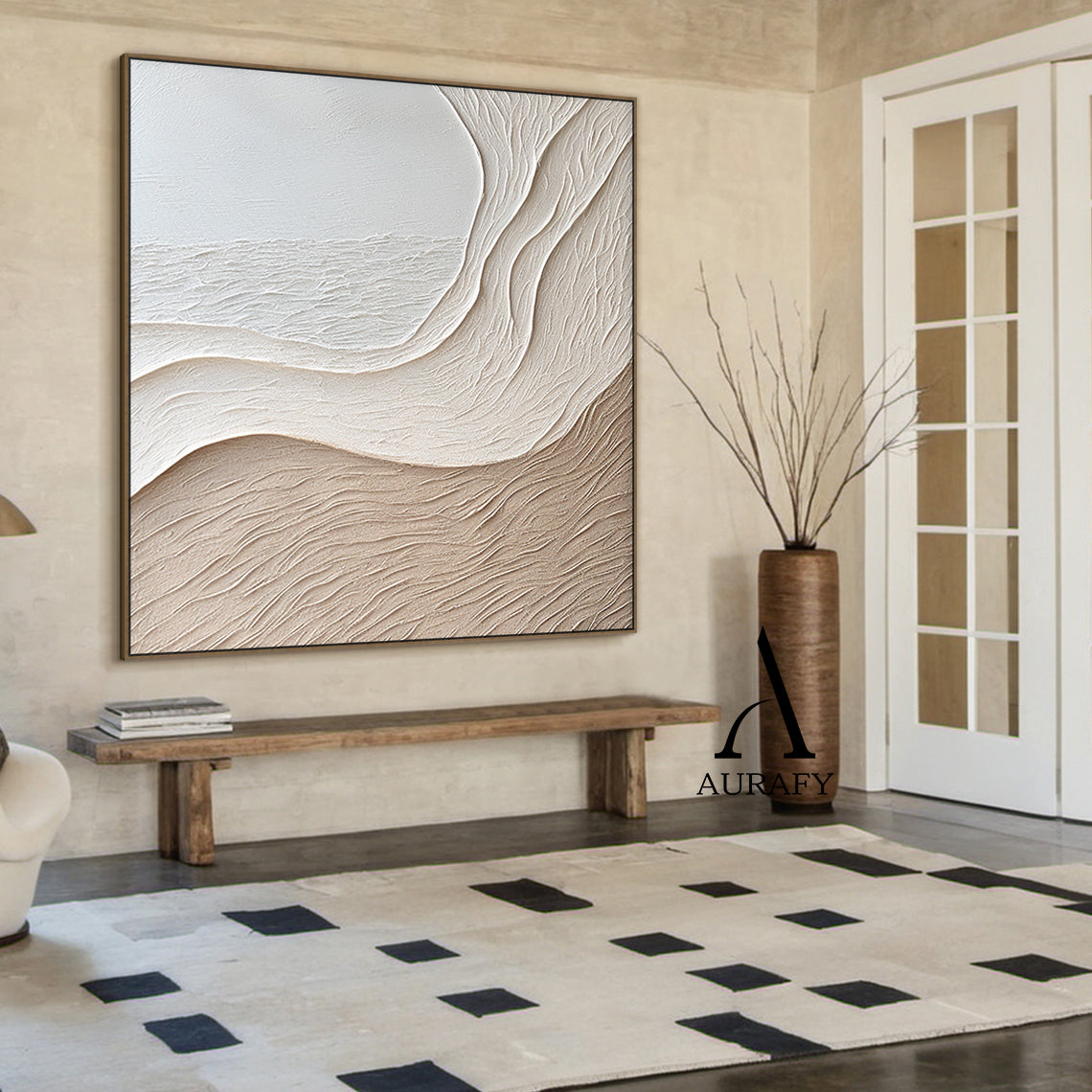 Aurafy AURA539 minimalist beige wall art, plaster textured high relief abstract canvas artwork. Displays the piece hung above a cream fabric sofa against a soft milk tea colored accent wall, its monochromatic soft gradient from cool off-white to warm light khaki beige blends seamlessly with fuzzy knit throw, natural rattan floor lamp and light oak coffee table decor accents, the organic undulating flowing curves inspired by wind-swept sand dunes and gentle shore slopes cast subtle soft shadows under warm re