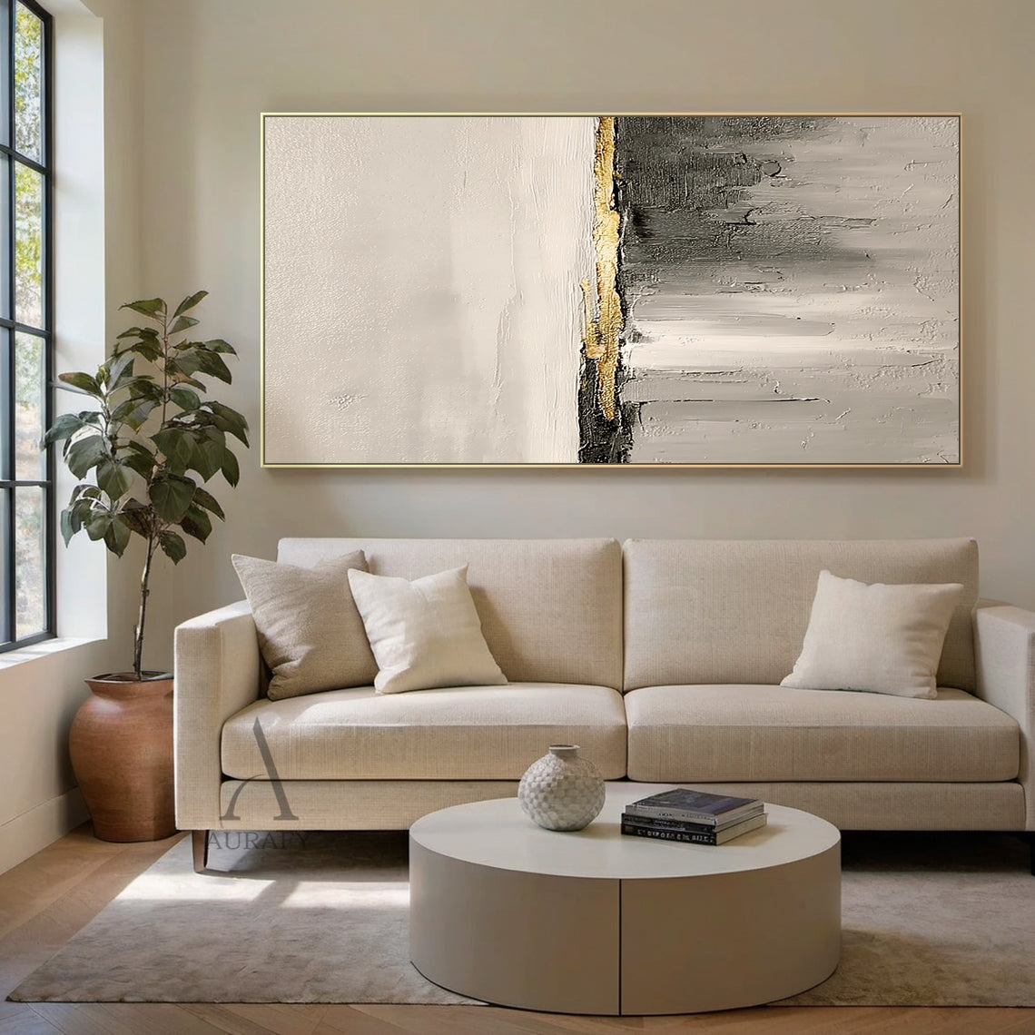 Hand-painted beige abstract impasto canvas wall art AURA718, displayed hanging on a matte warm white living room wall above a light oak low sideboard in a real neutral home styling scene, the artwork features soft warm off-white and light beige with subtle thick paint grain texture on the upper section, central horizontal matte charcoal stripe accented with raised grainy metallic gold thick paint band as focal point, lower area is gradient gray from light beige gray to dark charcoal with vertical sweeping b