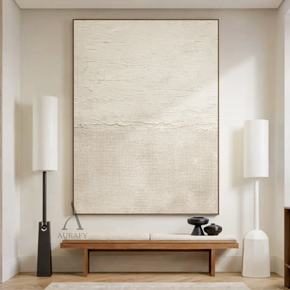 Beige general abstract wabi-sabi wall art hung in real Japandi minimalist home living space scene, upper part features light creamy off-white thick impasto plaster-like rough horizontal textured finish with subtle organic imperfections, lower part comes with slightly deeper warm beige fine linen grid woven texture, connected by a raw uneven handcrafted torn-edge seam, monochromatic neutral tactile canvas artwork displayed against light oak backdrop as decor effect reference, SKU AURA722