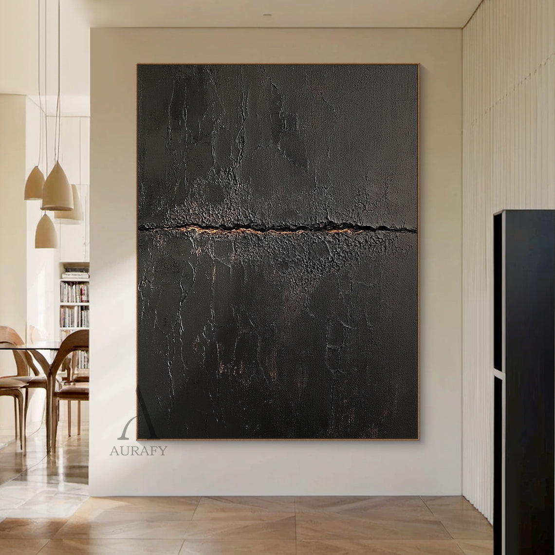 Black abstract textured impasto canvas wall art AURA723 hung above light oak low console table in sunlit warm japandi entryway, deep matte black surface with heavy crackle texture resembling aged cracked lacquer or charred earth, a rough horizontal split runs across the center of the piece with subtle warm earthy gold underlayer exposed, fine organic fissures spread out from the split, raw wabi-sabi tactile artwork perfect for adding textural contrast to light minimalist, japandi and warm contemporary inter