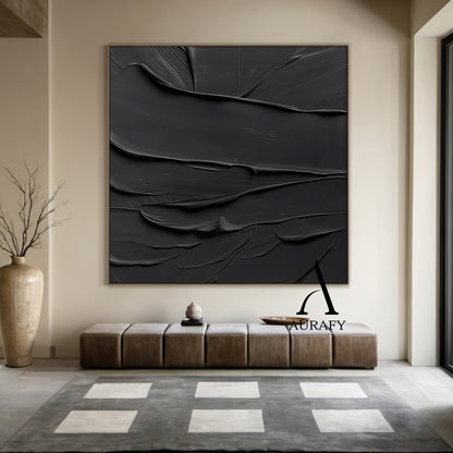 Black minimalist textured abstract wall art, featuring thick impasto knife-scraped matte black paint strokes with natural flowing undulations, raised ridges and subtle brush marks. All light and shadow variations come from the dimensional texture's light reflection difference, no extra pigments are added, with a tiny AURAFY brand logo at the bottom right corner, suitable for wabi-sabi, Japandi, modern industrial interior decor.