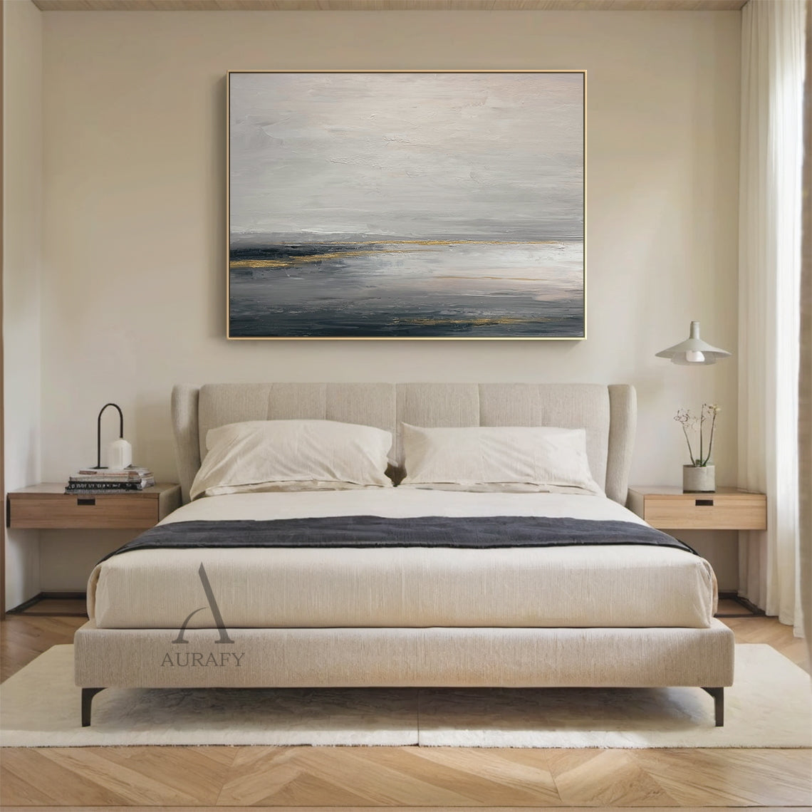 General Abstract gray beige canvas wall art (AURA626) displayed in modern home interior scene, features the signature layered muted gray shades (light, medium, dark) base with soft beige transition zones, accented with subtle shimmering golden streaks and patches. The tactile textured brush stroke layers present well against the neutral backdrop: loose hazy upper light gray and beige areas evoke misty cloud imagery, thick deep gray lower sections mimic dark water surface, golden elements simulate natural li
