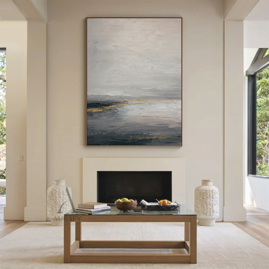 General Abstract gray beige canvas wall art (AURA626) displayed in Nordic light luxury dining room interior scene, features the signature layered muted gray shades (light, medium, dark) base with soft beige transition zones, accented with subtle shimmering golden streaks and patches. The tactile textured brush stroke layers present well against the creamy white backdrop: loose hazy upper light gray and beige areas evoke misty mountain fog imagery, thick deep gray lower sections mimic calm lake surface, gold