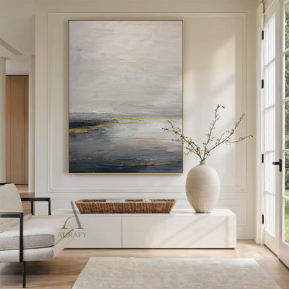 General Abstract gray beige canvas wall art (AURA626), features layered muted gray shades (light, medium, dark) as base with soft beige transition zones, accented with subtle shimmering golden streaks and patches. Tactile textured brush strokes build abstract layers: loose, hazy upper light gray and beige areas evoke misty cloud or fog imagery, thick deep gray lower layers mimic dark water or ground, golden elements simulate natural light reflection. Calm minimalist luxe abstract artwork for modern interior