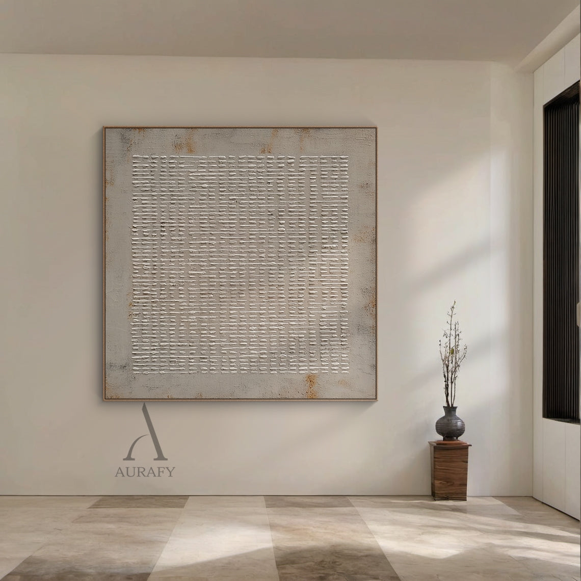 Lifestyle interior display shot of abstract gray high-relief impasto grid wall art AURA405, handcrafted raised off-white irregular woven-style grid strokes on muted textured gray background with subtle rust brown weathered accents at edges. This textural minimalist industrial wabi-sabi artwork is presented hung above a low-profile light wood Japandi storage cabinet in a sunlit neutral-toned living space, suitable for Japandi, quiet luxury, neutral modern home and public commercial space decor.
