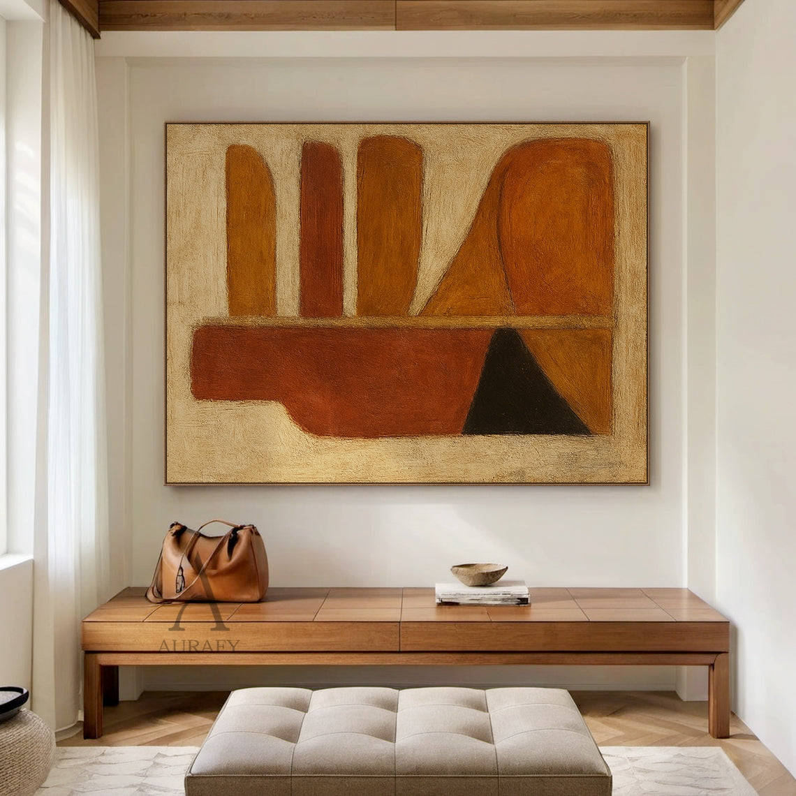 Handcrafted abstract brown wall art with tactile brushstroke texture and organic geometric composition, styled in a bright open-concept home dining space. The piece retains its signature design: left side with a vertical deep rust red-brown bottle-shaped silhouette, matched with black and orange-brown triangular blocks at the base, right side with rounded horizontal strips in warm amber, rust and brown tones plus curved orange-brown blocks, all set against a muted off-white textured background. This warm mi