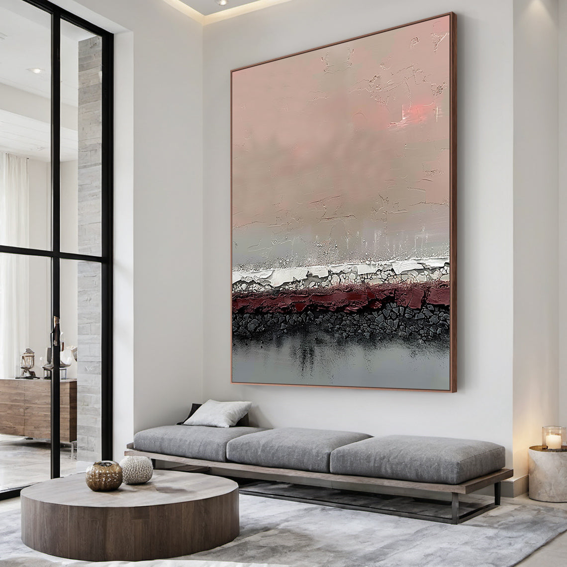 Vertical abstract art painting with layered textures: soft blush pink upper section, muted taupe gradient, textured white-silver crackle band, deep burgundy red layer, charcoal black crackle base, and cool gray bottom. Framed in warm metallic border, displayed on a light gray concrete accent wall in a minimalist modern study paired with a walnut writing desk and black leather ergonomic chair—ideal statement decor for contemporary living areas, home offices, or dining room focal points. This piece blends ear