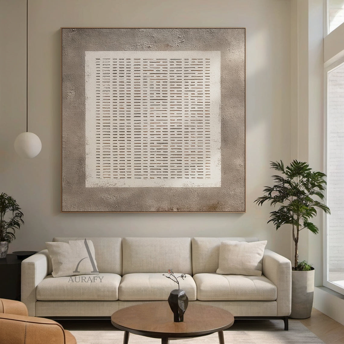 Abstract Gray Plaster Textured Wall Art AURA630: the artwork is hung on a soft light gray living room wall beside a linen sofa and small potted green plant, it adopts rough mottled gray plaster as the base, comes with a central white square with subtle hand-drawn uneven edges filled with orderly arranged repeating horizontal short line grid, gaps between lines reveal the gray base, the neutral monochrome gray and white minimalist abstract design is suitable for Japandi, minimalist, industrial style interior