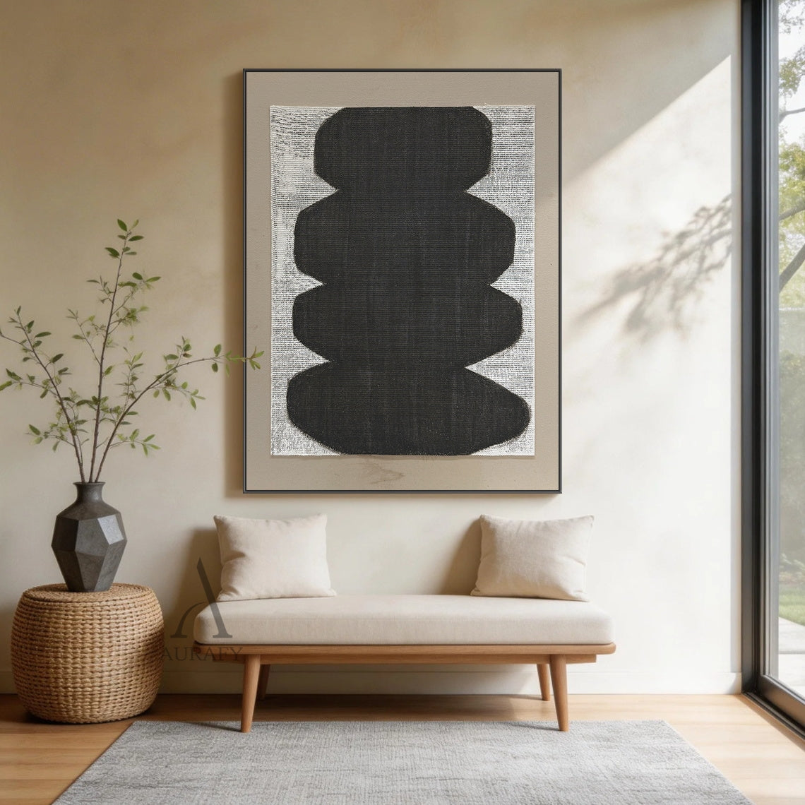 Minimalist abstract Japandi wabi-sabi wall artwork AURA727 staged in a sunlit cozy Japandi open-concept dining nook, square raw woven canvas with clear grid texture is mounted on warm beige limewash textured wall between two light oak floating shelves, features stacked soft curved matte black organic form with no sharp edges, uses monochrome black, white and neutral gray color palette, canvas weave texture is visible through both painted and unpainted areas, paired with a light taupe matte border, styled al
