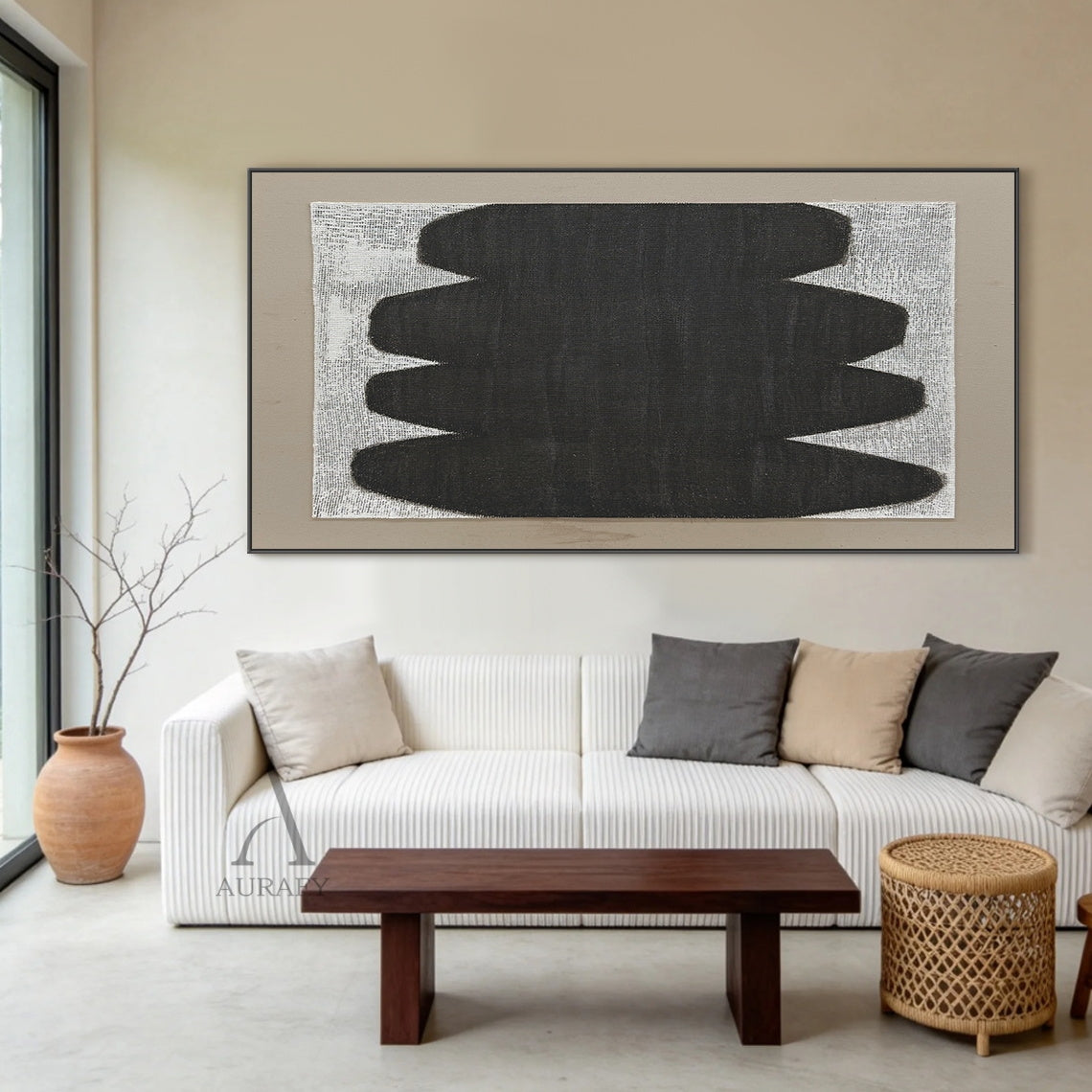 Minimalist abstract Japandi wabi-sabi wall artwork AURA727 staged in a sunlit cozy Japandi open-concept dining nook, square raw woven canvas with clear grid texture is mounted on warm beige limewash textured wall between two light oak floating shelves, features stacked soft curved matte black organic form with no sharp edges, uses monochrome black, white and neutral gray color palette, canvas weave texture is visible through both painted and unpainted areas, paired with a light taupe matte border, styled al