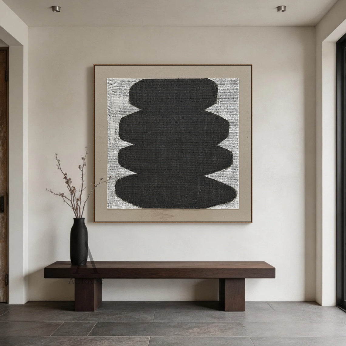 Minimalist abstract Japandi wabi-sabi wall artwork AURA727, square raw woven canvas with clear grid texture, features stacked soft curved matte black organic form with no sharp edges, monochrome black, white and neutral gray color palette, canvas weave texture visible through both painted and unpainted areas, set against a light taupe matte border, tactile neutral decor piece for calm curated modern home spaces.