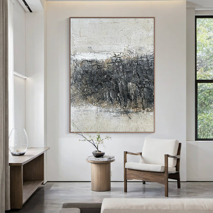 Abstract Black White Crackle Texture Art (AURA219) | Modern Abstract Minimalist Luxe Wall Decor. Thick knife strokes, tactile plaster finish, 3D impasto, subtle light gold/beige undertones. Displayed above a light wood sofa in a serene Japandi living room, serving as a striking focal point. Balances deep black, soft off-white & gray with intentional crackle texture (wabi-sabi influences). Framed abstract piece with strong light-dark contrast and layered, tactile surface—ideal for modern bedrooms, home offic