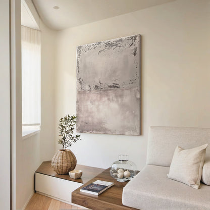 Wabi Sabi Abstract Tactile Impasto Gray Wall Art with Muted Pink Undertones & Distressed Surface (AURA191) - A warm focal point in a cozy bohemian bedroom. Features layered impasto texture, weathered patterns, soft silvery grays to deep charcoal, subtle pink hints. Displayed above a warm wooden bed frame with beige linen bedding, complementing woven macramé wall hangings, a potted fiddle leaf fig in the corner, and soft ambient light from a ceramic table lamp. Ideal for bohemian, organic home decor.