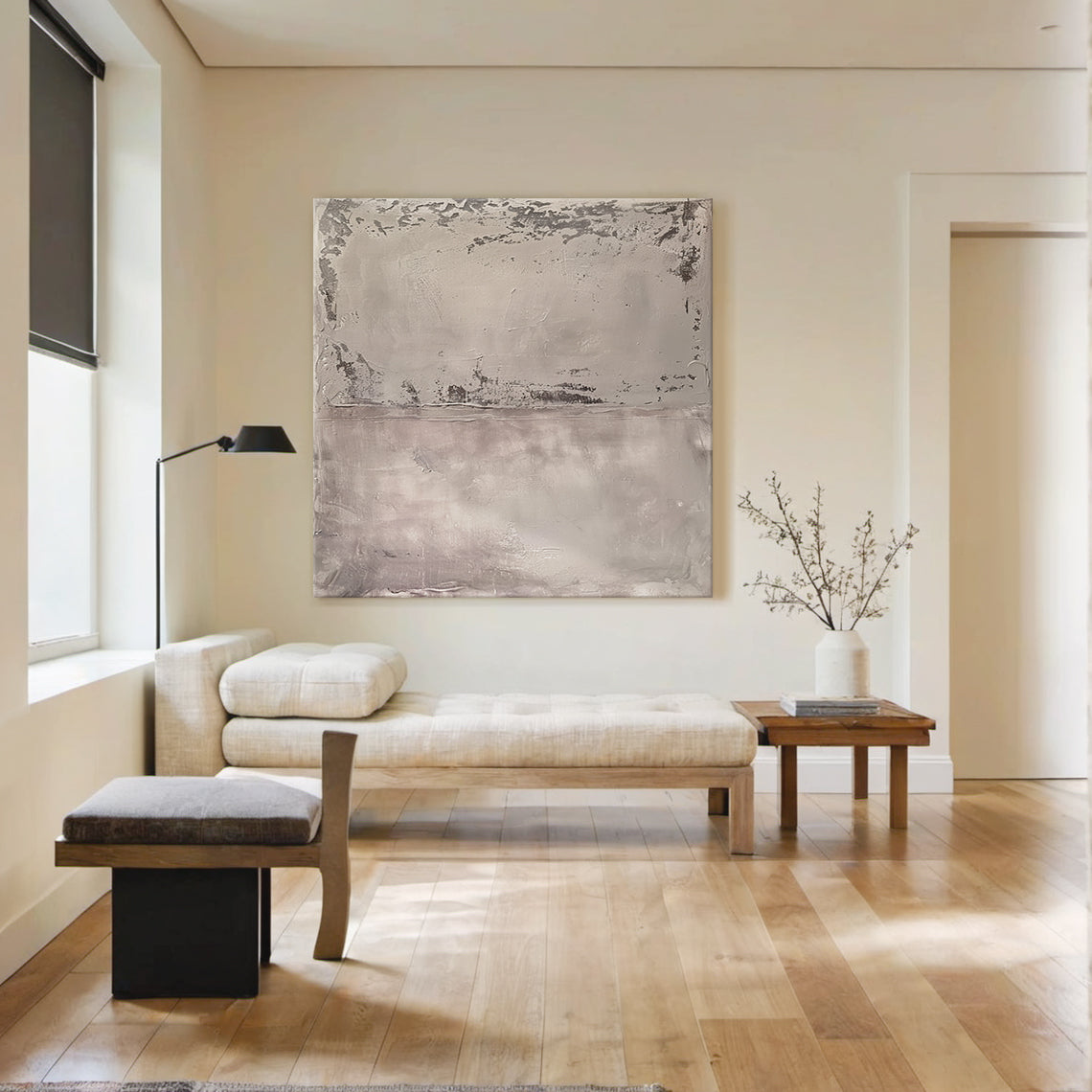 Wabi Sabi Abstract Tactile Impasto Gray Wall Art with Muted Pink Undertones & Distressed Surface (AURA191) - A serene focal point in a bright modern living room. Features layered impasto texture, weathered patterns, soft silvery grays to deep charcoal, subtle pink hints. Displayed against neutral walls, complementing natural light, wooden console, white sofa, and large windows with greenery views. Ideal for minimalist, organic home decor.