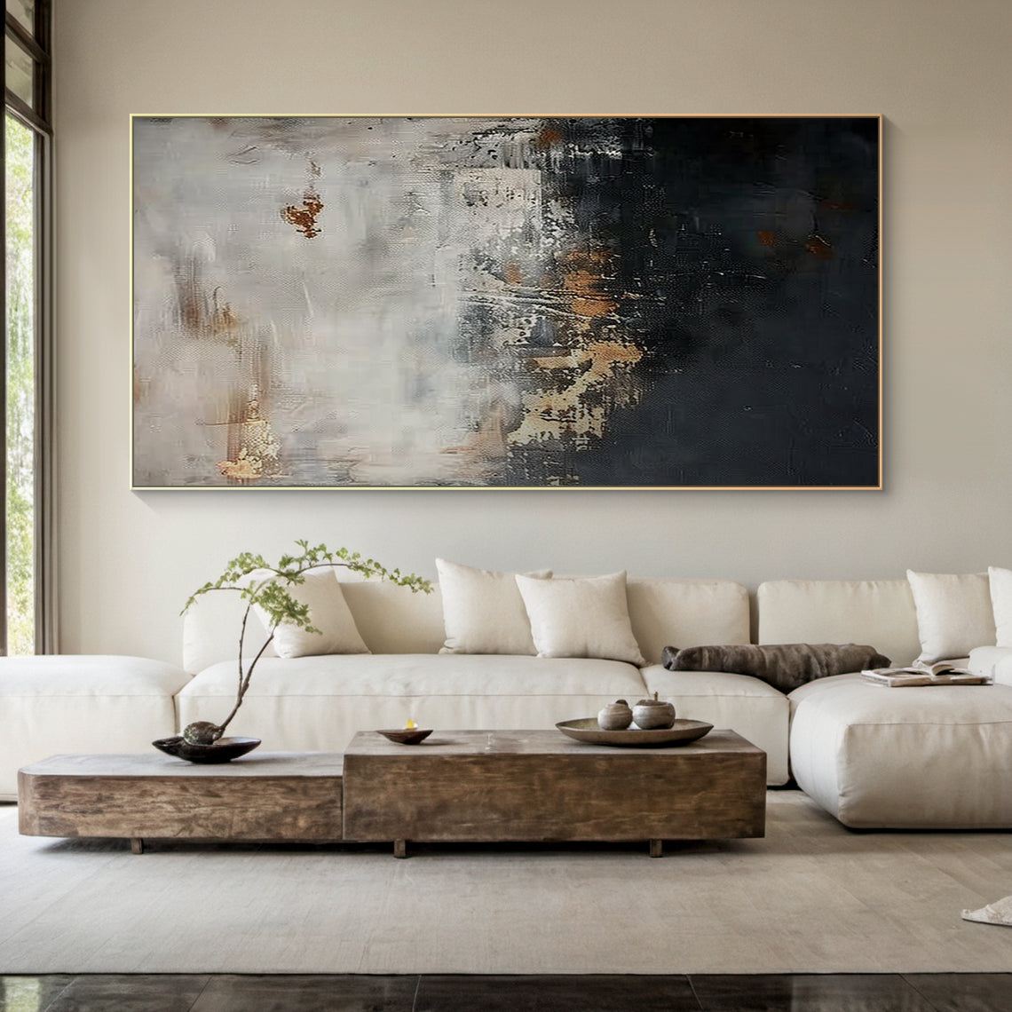 Wabi Sabi abstract sculpted canvas art with impasto knife strokes and tactile surface—deep black lower section, light gray upper layer, golden copper accents. Displayed in a serene modern organic space: light beige walls, wooden ceiling, soft-cushioned bench, gray rug, metallic vase with branches, natural light. Embraces Wabi Sabi’s imperfect beauty and subtle warm softness (Pink vibe) for calm, minimalist home decor. AURA196.