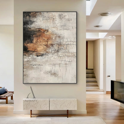 Scened Abstract textured Wabi-sabi wall art (AURA636), features hand-applied cracked plaster texture with thick rough paint finish, light beige as base tone, warm brown color block sits on middle left as visual focus, dark gray near black gradient at top left, non-figurative abstract composition, presents weathered aged vintage serene vibe, real shot displayed in a soft-toned modern minimalist bedroom matched with low-profile oak bed frame, creamy linen bedding and matte terracotta decor pieces, ideal for a
