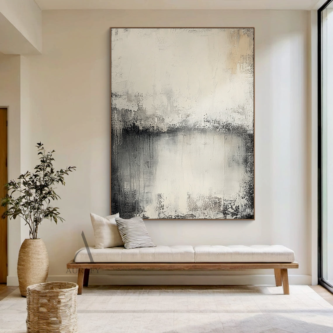 Wabi Sabi Beige General Abstract Plaster Textured Canvas Wall Art AURA720 (Living Room Home Decor Scene Display), features soft muted neutral palette with warm beige, creamy off-white, blended charcoal gray and deep black gradient transitions, hand-applied impasto finish with distressed worn edges, subtle vertical paint drips, rough brushed striations and uneven peeling-like surface details, non-directional minimalist abstract artwork presented in a bright airy modern residential living space, perfect for J