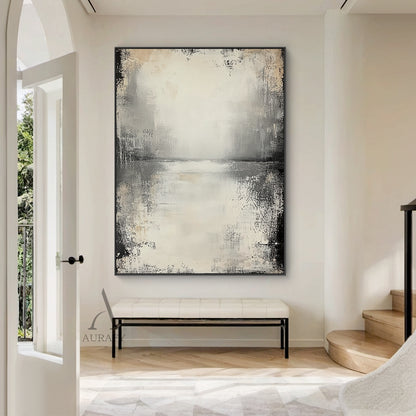 Wabi-sabi beige abstract textured canvas wall art AURA719, styled and displayed hung above a low-profile light oak sideboard in a sun-drenched minimalist Japandi living room scene, features a muted neutral color palette of off-white, pale beige, light to deep charcoal gray with faint warm brown accents, hand-finished distressed brushed & wiped texture with rough worn edges, subtle horizontal abstract sky-water horizon line across the upper middle, natural dark vignette fading from edges to the light beige b