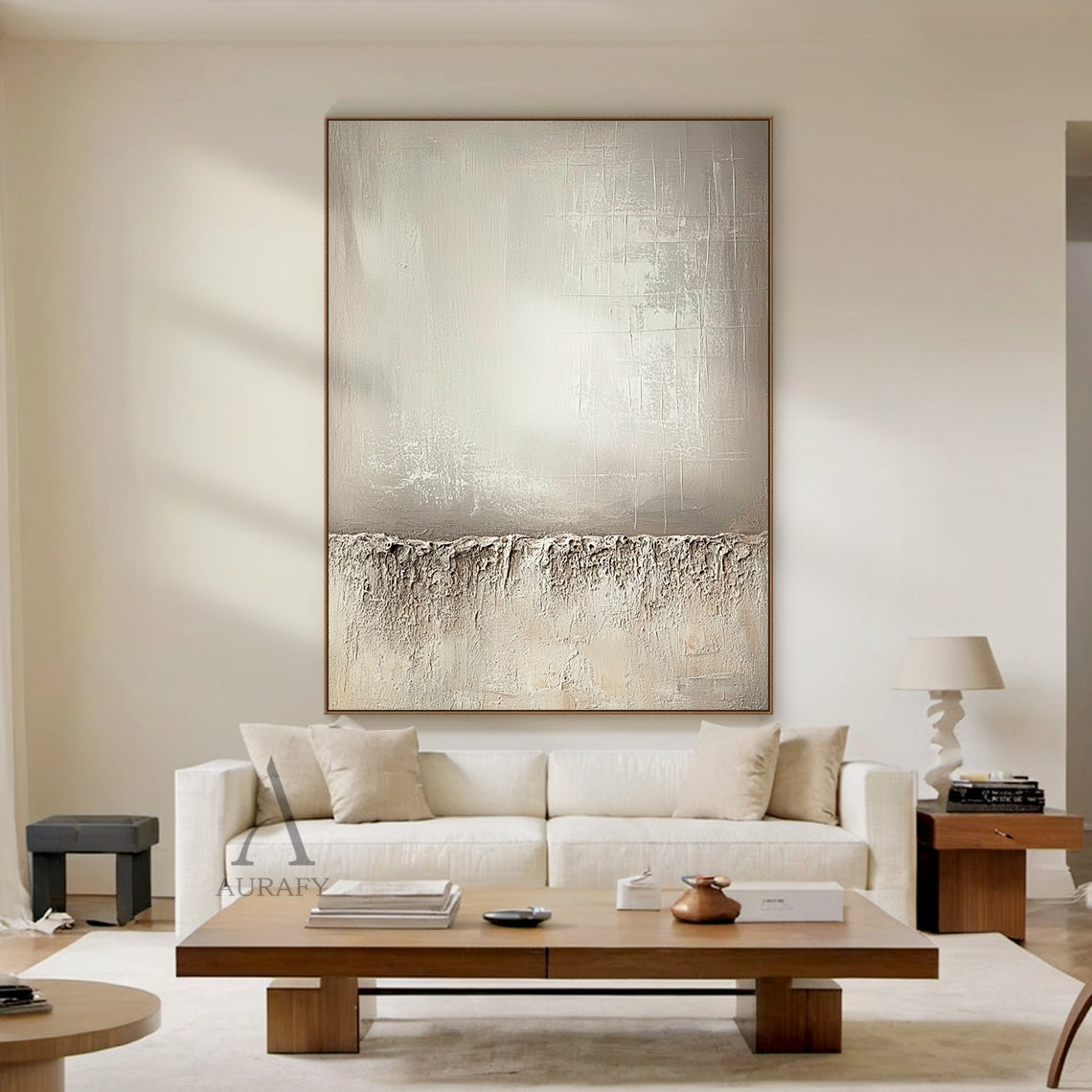 Beige wabi-sabi abstract canvas wall art AURA724 styled in a neutral Japandi home scene. It retains the classic split composition design: the lower section adopts thick rugged impasto texture like weathered rock and dry land with natural uneven edges, the upper left part has a smooth brushed warm beige gradient with faint brush stroke textures, the upper right part comes with subtle etched cross-hatch lines and mottled worn details. The whole work uses monochromatic neutral tones of beige, taupe and off-whi