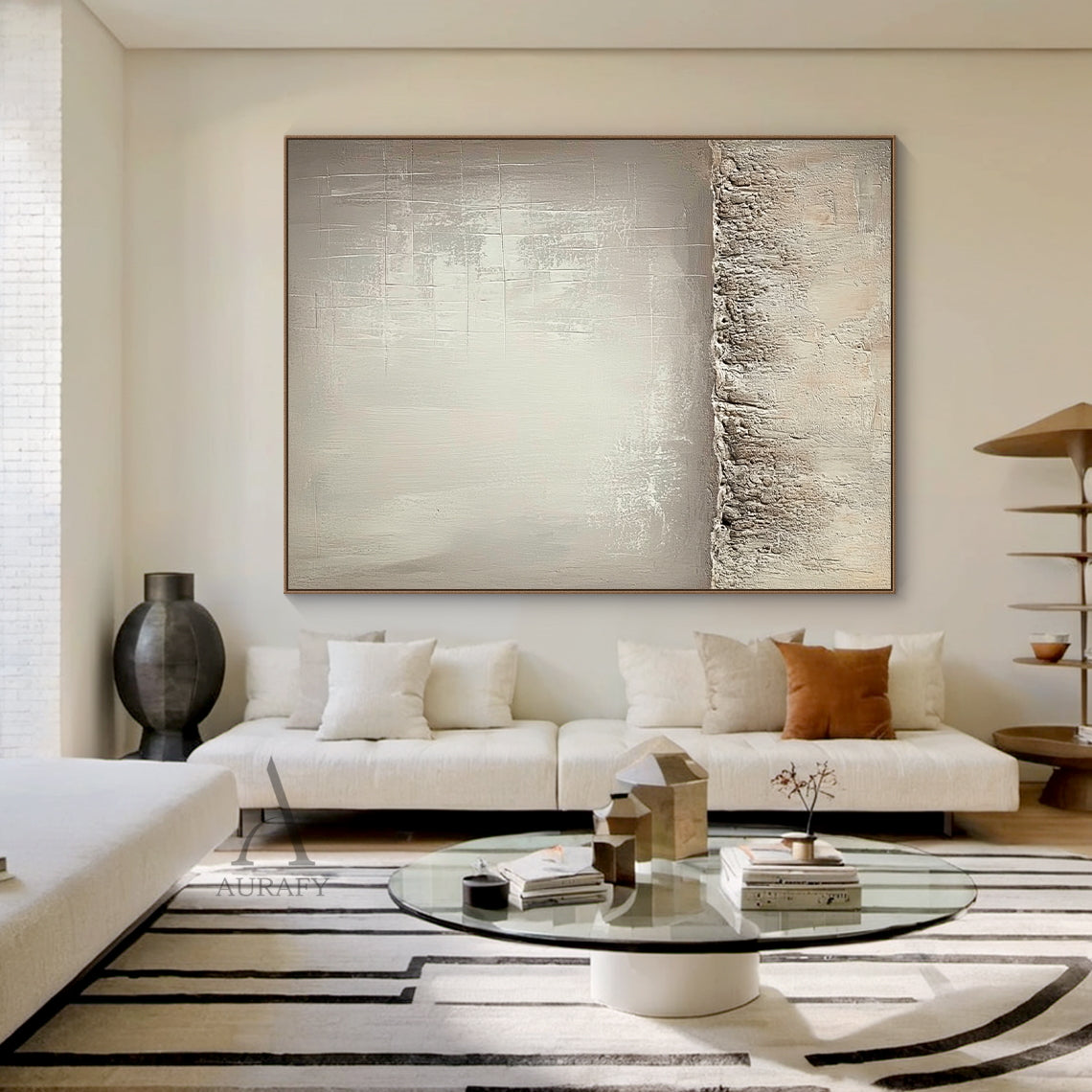 Beige wabi-sabi general abstract canvas wall art AURA724 with split composition. Lower section adopts thick rugged impasto texture like weathered rock and dry land with natural uneven edges. Upper left part has smooth brushed warm beige gradient with faint brush stroke textures, upper right part comes with subtle etched cross-hatch lines and mottled worn details. The whole work uses monochromatic neutral tones of beige, taupe and off-white, it is a minimalist Japandi luxe tactile artwork for neutral home de