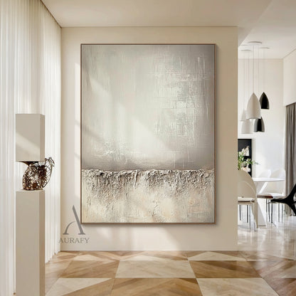 Beige wabi-sabi abstract canvas wall art AURA724 styled in a warm log-style Japandi living-dining integrated home scene. It retains the classic split composition design: the lower section adopts thick rugged impasto texture like weathered rock and dry land with natural uneven edges, the upper left part has a smooth brushed warm beige gradient with faint brush stroke textures, the upper right part comes with subtle etched cross-hatch lines and mottled worn details. The whole work uses monochromatic neutral t