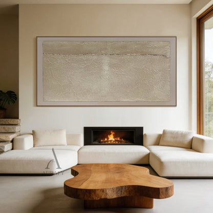 Wabi-Sabi Beige Handmade Textured Abstract Canvas Wall Art AURA734. Styled entryway and casual dining nook display of the horizontal abstract artwork, featuring warm beige grainy impasto central panel, natural fine crackle textures across the surface, a thin irregular dark horizontal crack splitting the panel, bordered by soft pale off-white smooth frame, shown hung above a compact light oak dining bench against a warm muted gray wall, matched with woven rattan dining chairs and wool tufted floor rug as neu