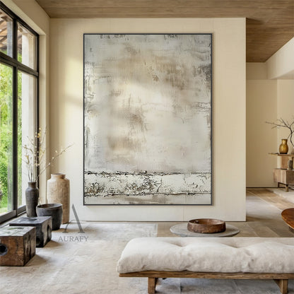 Wabi Sabi beige minimalist abstract wall art (Product ID: AURA808), presented in a real interior placement scene. It adopts a muted neutral earthy color palette covering light off-white, pale gray to soft warm brown, the main surface mimics the texture of aged plaster/cement wall, with subtle brush traces, shallow scratches and mottled worn marks full of vintage sense. A horizontal distressed peeling textured band with rugged uneven surface is set at the bottom, perfectly fits Japandi, minimalist, industria