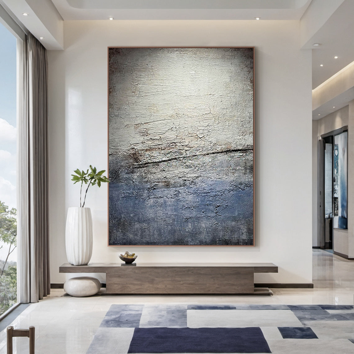 Wabi Sabi Gray Blue Abstract Textured Wall Art AURA225 - Vertical canvas with cracked layered finish in muted grays, soft blues & warm neutrals, styled as a focal point in a sunlit home office. Ideal home office statement piece, dining room wall accent or hallway decor. Complements minimalist, contemporary or Scandi decor styles. Adds depth & serenity to modern interiors, merging organic imperfection with modern elegance for timeless charm.