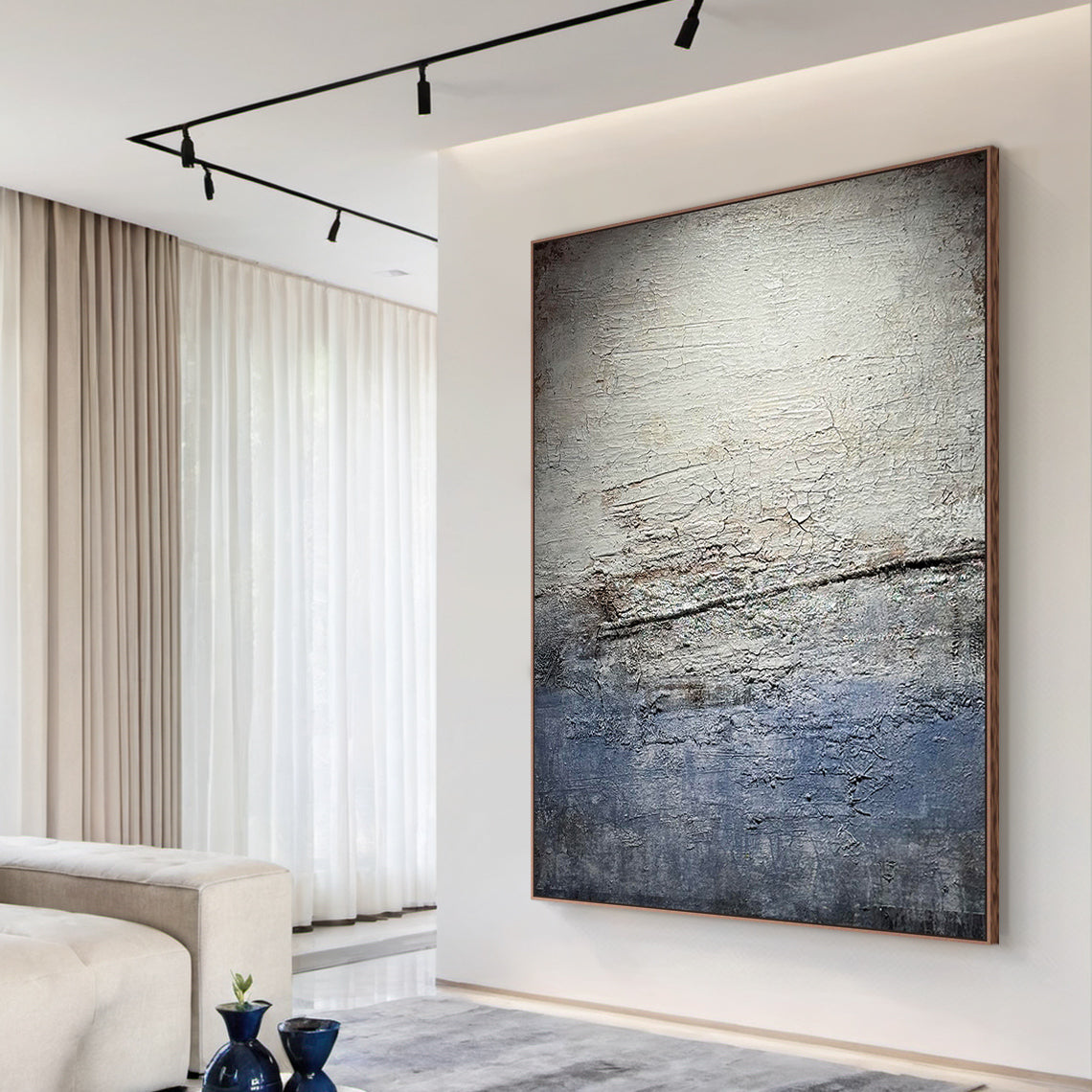 Wabi Sabi Gray Blue Abstract Textured Wall Art AURA225 - Vertical canvas with cracked layered finish in muted grays, soft blues & warm neutrals, styled as a striking focal point in a cozy neutral-toned living room. Ideal living room statement piece, bedroom wall accent or entryway decor. Complements minimalist, contemporary or Scandi decor styles. Adds depth & calm to modern interiors, blending organic imperfection with modern elegance for timeless appeal.