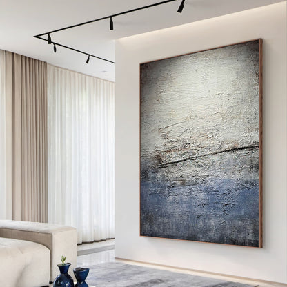 Wabi Sabi Gray Blue Abstract Textured Wall Art AURA225 - Vertical canvas with cracked layered finish in muted grays, soft blues & warm neutrals, styled as a striking focal point in a cozy neutral-toned living room. Ideal living room statement piece, bedroom wall accent or entryway decor. Complements minimalist, contemporary or Scandi decor styles. Adds depth & calm to modern interiors, blending organic imperfection with modern elegance for timeless appeal.